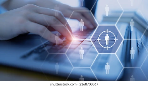 Hand typing on laptop with person icons on connected hexagons